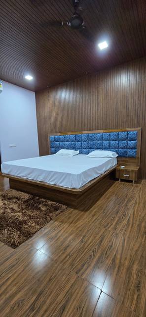Bedroom with a king bed and a blue padded headboard