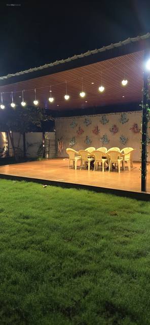 Gazebo set with a long dining table under string lights at night